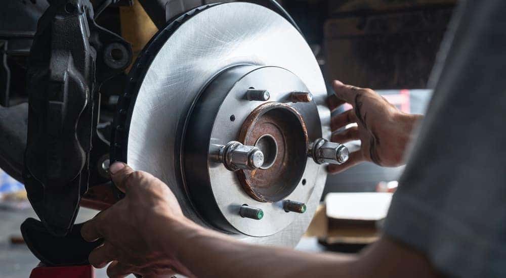 A mechanic is shown installing a car brake during auto repair.