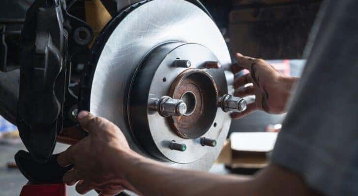 A mechanic is shown installing front brake rotors during an auto repair near Pueblo.