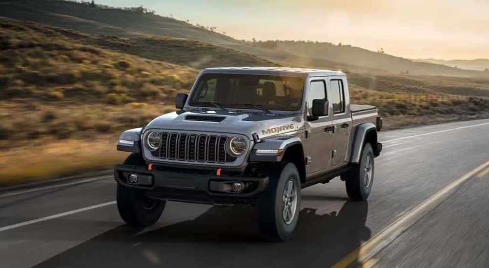 A silver 2025 Jeep Gladiator Mojave is shown driving after visiting a Jeep Gladiator for sale in Colorado Springs.