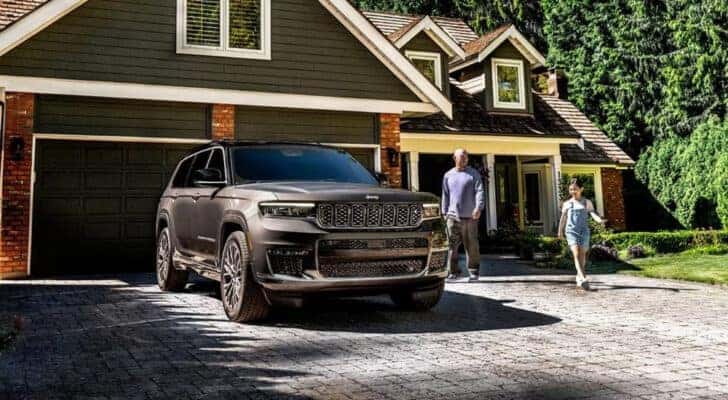 A grey 2025 Jeep Grand Cherokee is shown from the front at an angle.