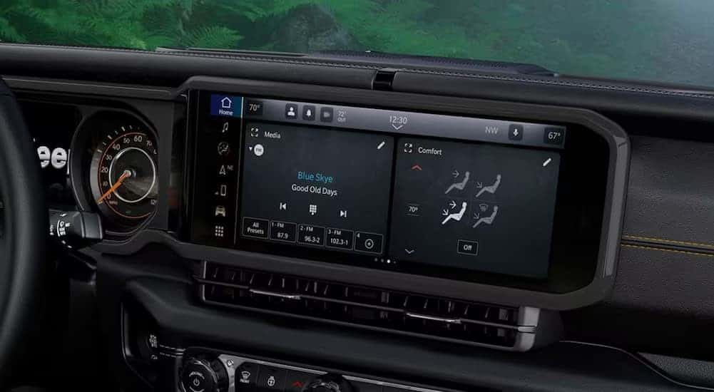 A close-up of an infotainment screen is shown in a 2025 Jeep Wrangler for sale near Pueblo.
