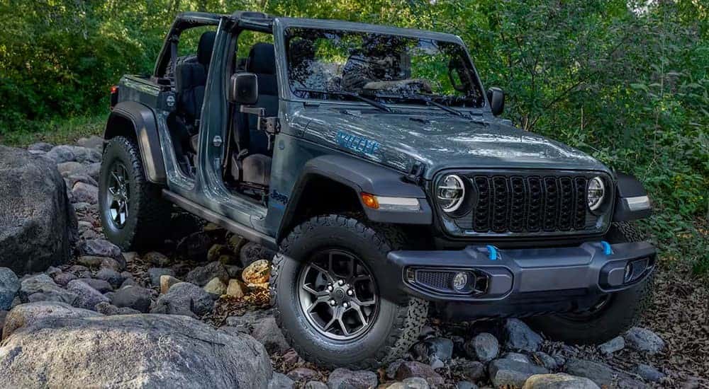 A gray 2025 Jeep Wrangler 4xe Willys is shown off-roading.