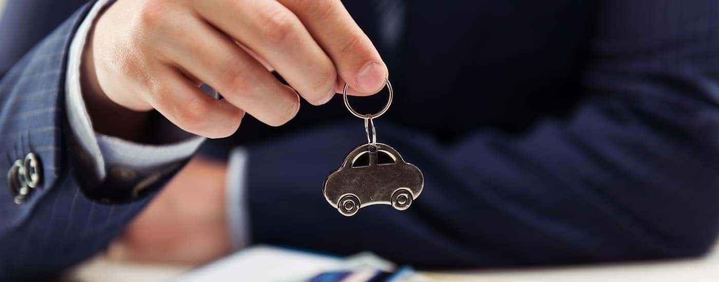 Car salesman holding a keychain.