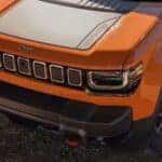 Hood of an orange 2026 Jeep Recon for sale parked in a desert.