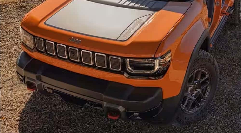 Hood of an orange 2026 Jeep Recon for sale parked in a desert.