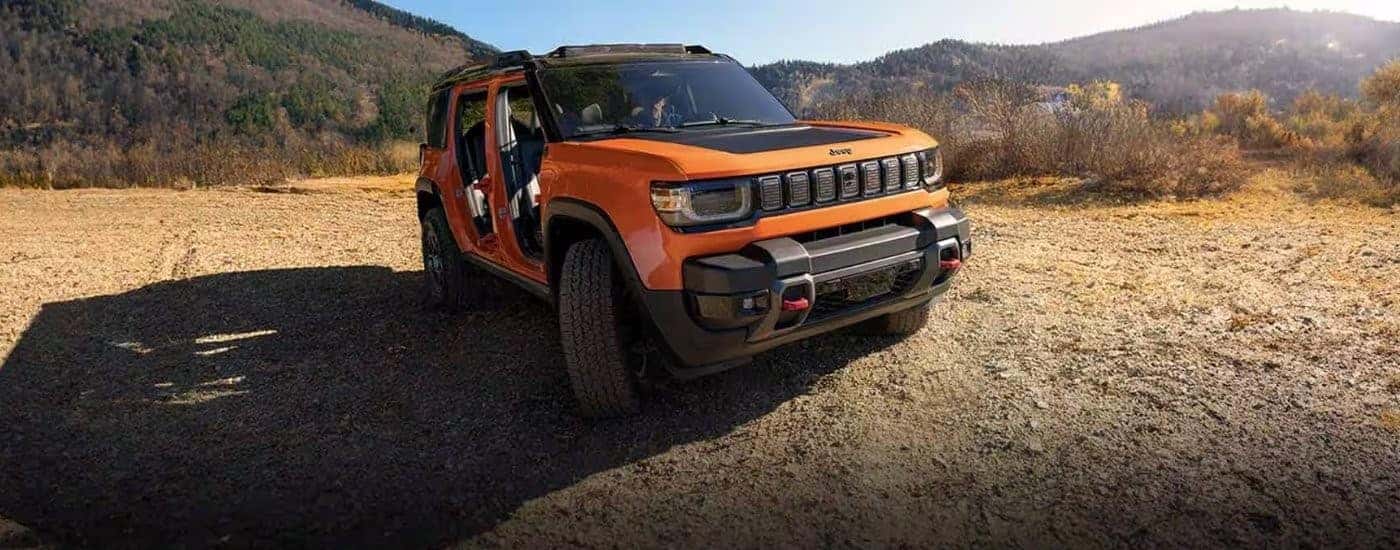 An orange 2025 Jeep Recon parked off-road.