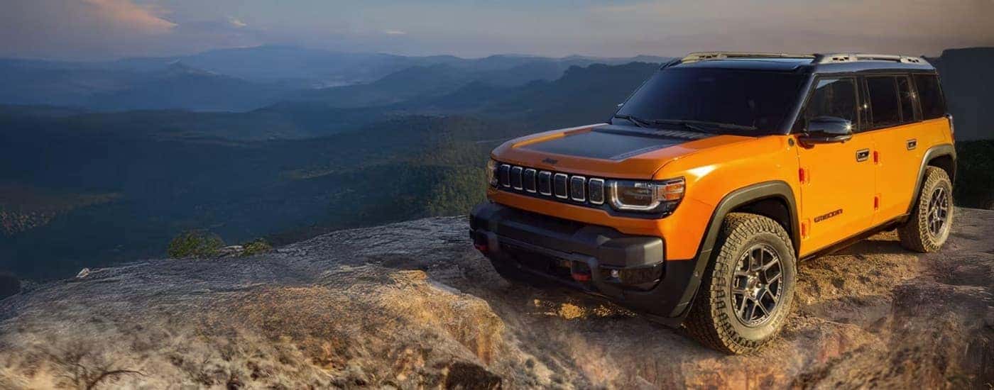 An orange 2025 Jeep Recon parked near an overlook.