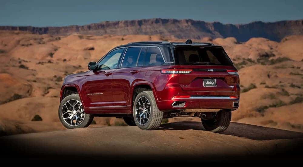 A red 2022 Jeep Grand Cherokee from the rear after leaving a dealer that has used cars for sale.
