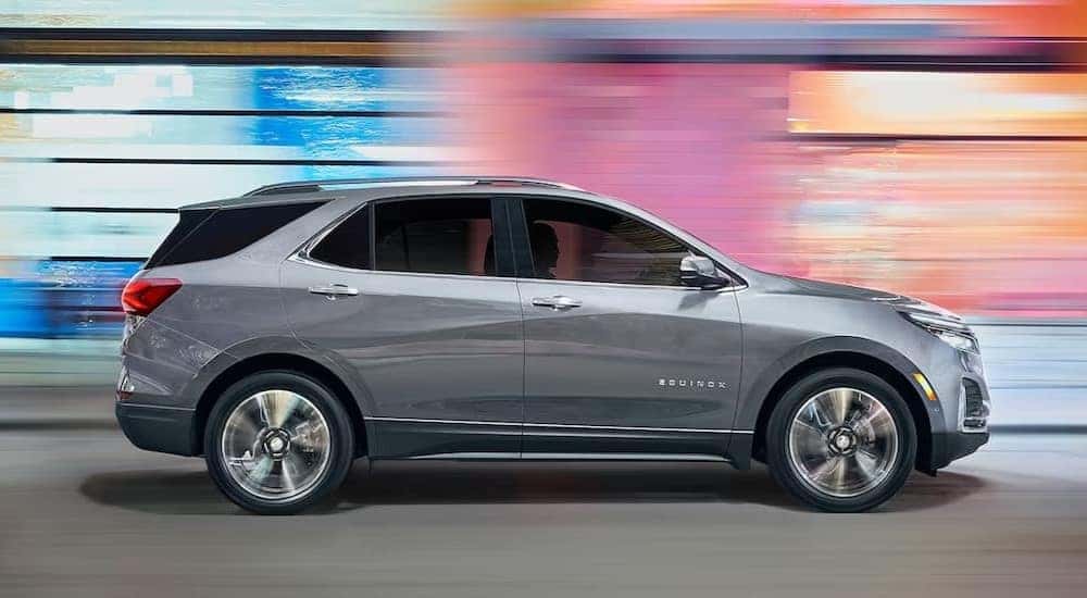 A silver 2023 Chevy Equinox driving to view used SUVs for sale near Pueblo.