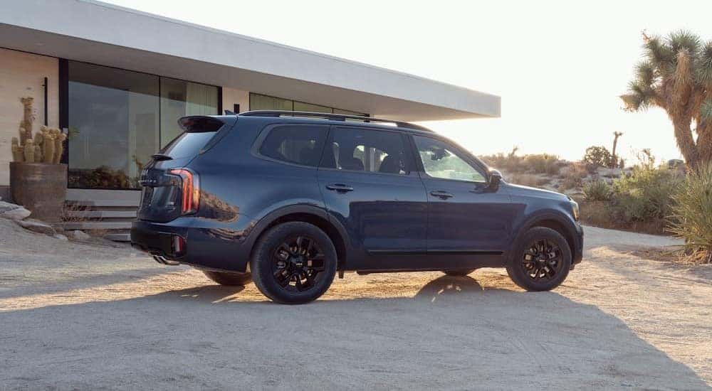 A blue 2024 Kia Telluride parked on a driveway.
