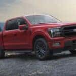 A red 2024 Ford F-150 Lariat parked off-road