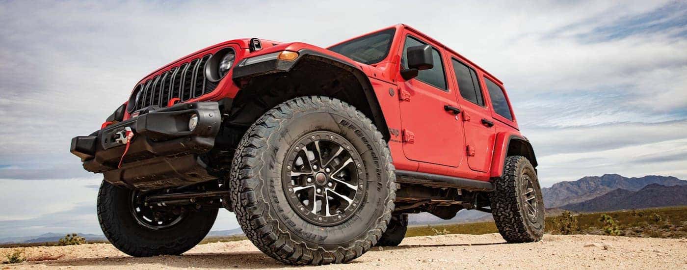 Red 2025 Jeep Wrangler parked in a desert.