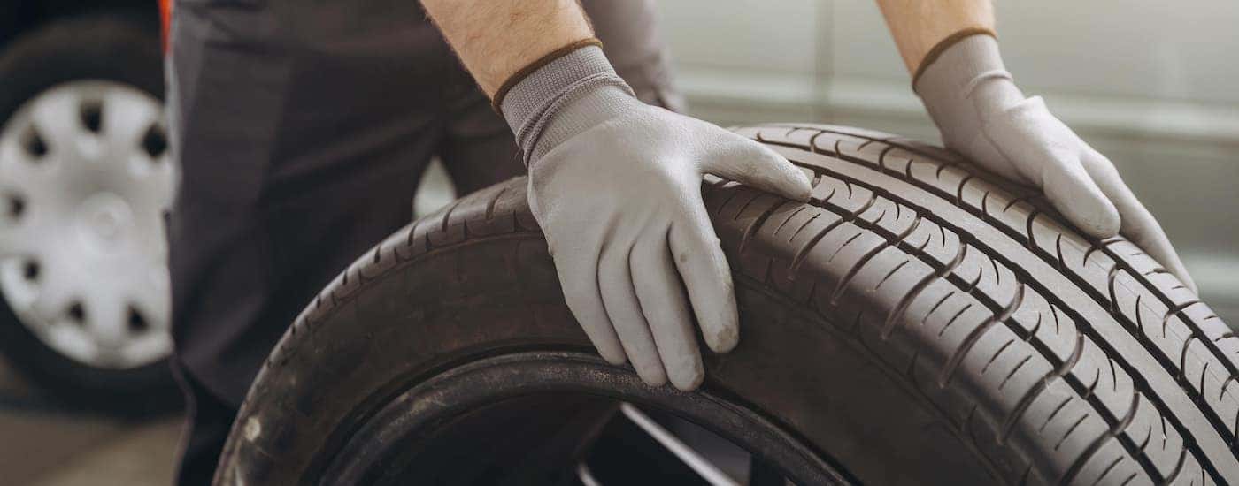 Mechanic rolling a tire.