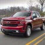 Red 2019 Chevy Silverado 1500 RST driving by a lake.