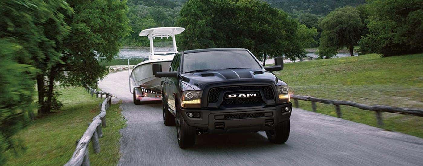 Grey 2019 Ram 1500 Classic towing a boat from a dealer with used trucks for sale in Colorado Springs.