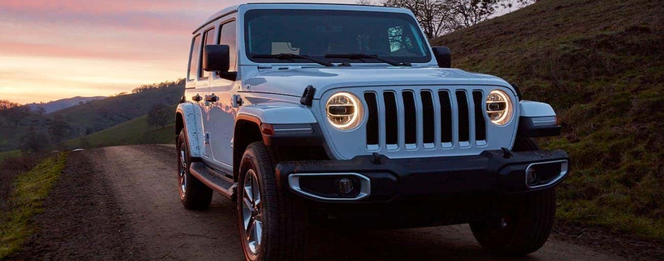 White 2019 Jeep Wrangler driving off-road.