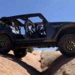 Grey 2025 Jeep Wrangler Rubicon off-roading on rocks