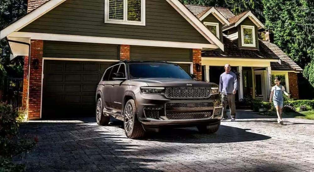 A gray 2025 Jeep Grand Cherokee L parked on a driveway.