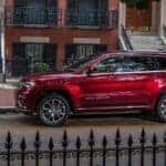 A red 2021 Jeep Cherokee parked in a city after viewing a used Jeep for sale.