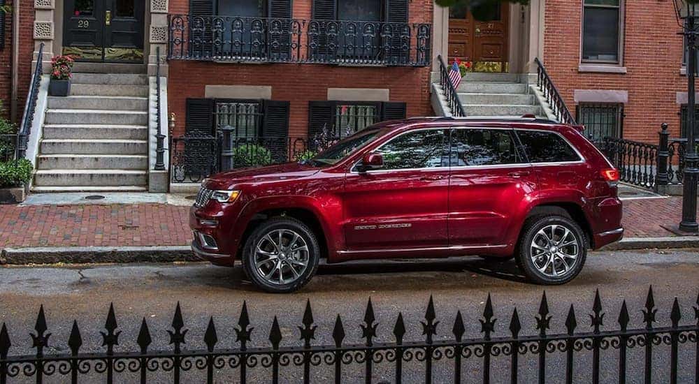 A red 2021 Jeep Cherokee parked in a city after viewing a used Jeep for sale.