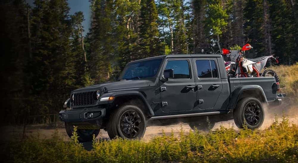 A black 2024 Jeep Gladiator Nighthawk driving off-road.