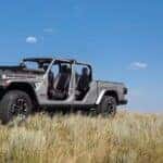 A silver 2024 Jeep Gladiator Rubicon parked in a field.