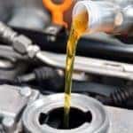 Service tech adding oil to a vehicle during an oil change