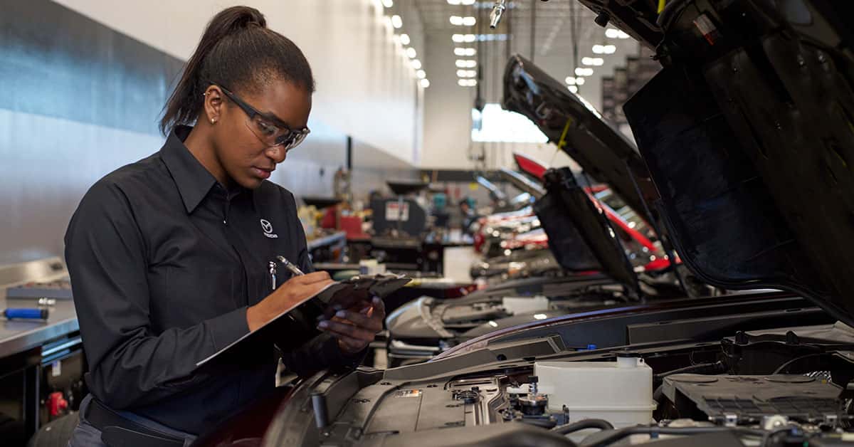 Mazda service technician inspecting a vehicle