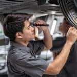 Mazda service technician inspecting tread depth
