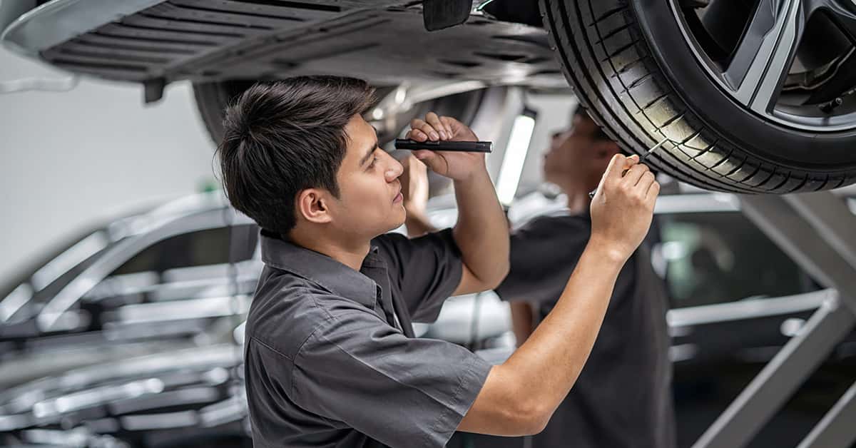 Mazda service technician inspecting tread depth