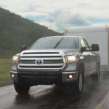 2017 Toyota Tundra driving in the rain pulling a trailer