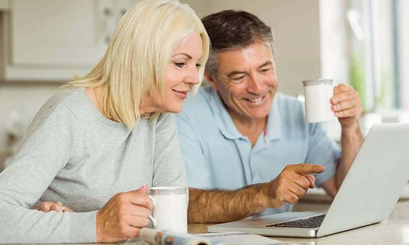 Older Man and Woman Using Computer to Value Their Trade In