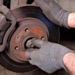 close up of technician working on brake pads