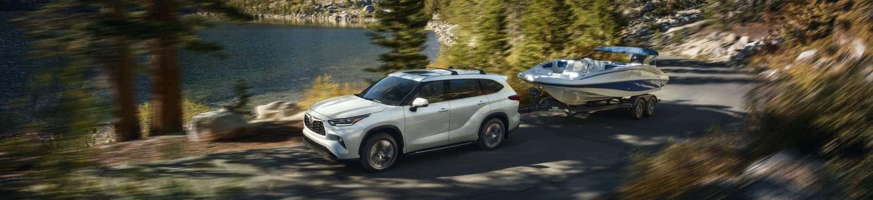 2022 Toyota Highlander XLE white towing boat along scenic lake